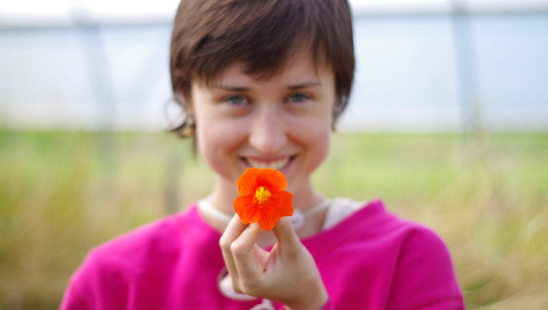 Farm intern holding regionally adapted flower